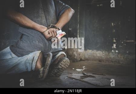 Donneur de drogue en état d'arrestation confiné avec des menottes, debout à côté d'un mur. Droit et police. Journée mondiale de la lutte contre la drogue Banque D'Images