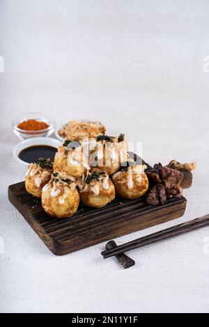 Le takoyaki est une cuisine de rue japonaise contenant du pieuvre, de la saucisse ou du fromage. garnir d'algues et de katsuobushi Banque D'Images