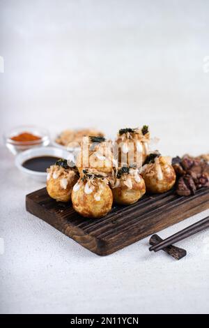 Le takoyaki est une cuisine de rue japonaise contenant du pieuvre, de la saucisse ou du fromage. garnir d'algues et de katsuobushi Banque D'Images