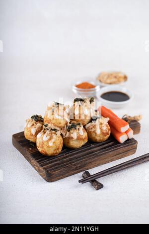 Le takoyaki est une cuisine de rue japonaise contenant du pieuvre, de la saucisse ou du fromage. garnir d'algues et de katsuobushi Banque D'Images