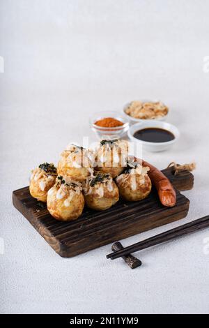 Le takoyaki est une cuisine de rue japonaise contenant du pieuvre, de la saucisse ou du fromage. garnir d'algues et de katsuobushi Banque D'Images