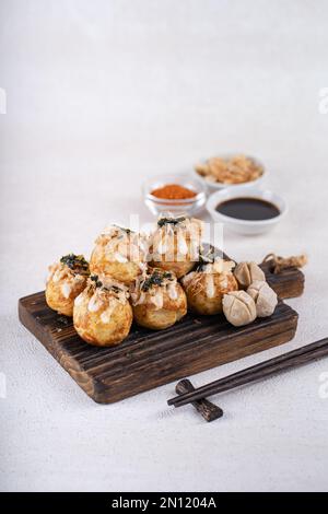 Le takoyaki est une cuisine de rue japonaise contenant du pieuvre, de la saucisse ou du fromage. garnir d'algues et de katsuobushi Banque D'Images