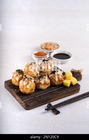 Le takoyaki est une cuisine de rue japonaise contenant du pieuvre, de la saucisse ou du fromage. garnir d'algues et de katsuobushi Banque D'Images