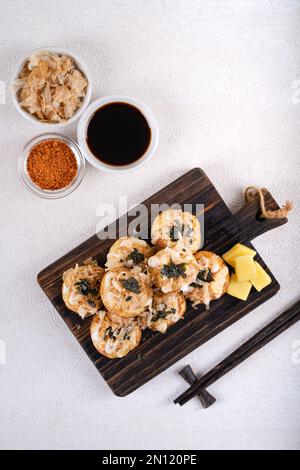 Le takoyaki est une cuisine de rue japonaise contenant du pieuvre, de la saucisse ou du fromage. garnir d'algues et de katsuobushi Banque D'Images