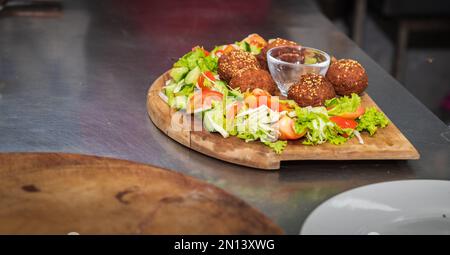 Assiette de falafel avec salade de légumes et sauce sur la table de cuisine gros plan. Banque D'Images