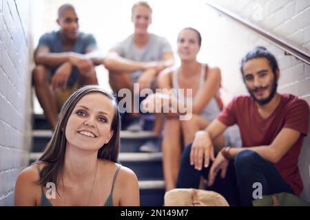 Détente avant la classe. étudiants de l'université assis sur les marches d'un escalier. Banque D'Images