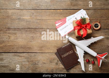 Composition de la pose à plat avec billets d'avion, avion jouet et passeports sur table en bois, espace pour le texte. Vacances de Noël Banque D'Images