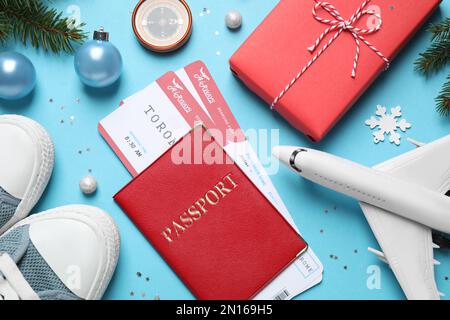 Composition de la décoration de Noël, passeport et billets d'avion sur fond bleu clair. Vacances d'hiver Banque D'Images