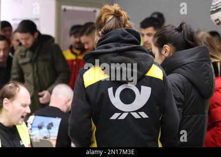 Krefeld, Allemagne. 06th févr. 2023. Les grévistes du bureau de poste et DHL s'enregistrer dans un pub de grève à Krefeld. Un attaquant porte une veste avec le logo Post. Le syndicat Verdi a une fois de plus appelé les travailleurs postaux de toute l'Allemagne à participer à une grève d'avertissement lundi et mardi dans le conflit salarial au Deutsche Post. Crédit : David Young/dpa/Alay Live News Banque D'Images