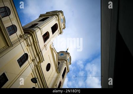 Ancienne église catholique jaune simple avec deux tours d'horloge identiques à Lichtental, Vienne, Autriche Banque D'Images