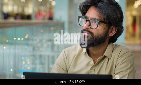 Concentré pensif indien bien réfléchi ethnique arabe multiraciale barbu homme d'affaires commerçant homme d'entrepreneur directeur général dans des lunettes avec Banque D'Images