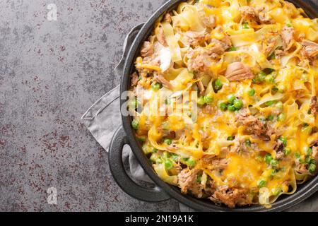 Cocotte de thon maison avec pâtes, petits pois, champignons et cheddar dans une poêle à frire sur la table. Vue horizontale du dessus Banque D'Images