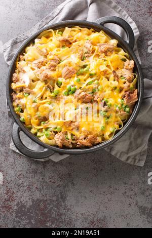 Cocotte de thon en conserve avec pâtes, pois verts, champignons et cheddar dans un plat de cuisson sur la table. Vue verticale du dessus Banque D'Images