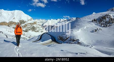 Femelle randonneur en orange par temps venteux à Luz-Ardiden, Pyrénées françaises, domaine skiable de France Banque D'Images