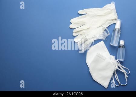 Composition de la couche plate avec gants médicaux, masques et désinfectant pour les mains sur fond bleu. Espace pour le texte Banque D'Images