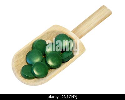 Pilules de spiruline et cuillère en bois isolées sur fond blanc Banque D'Images