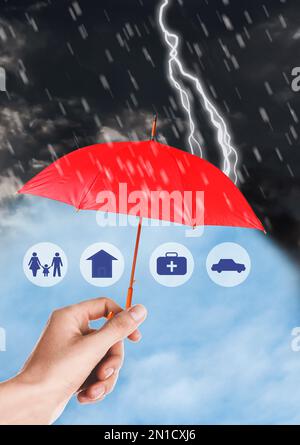 Concept d'assurance. Femme protégeant des illustrations avec un parapluie rouge de la tempête, gros plan Banque D'Images