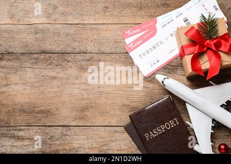 Composition de la pose à plat avec billets d'avion, avion jouet et passeports sur table en bois, espace pour le texte. Vacances de Noël Banque D'Images