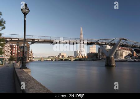 Vue panoramique du pont piétonnier traversant la Tamise à Londres avec gratte-ciel moderne en arrière-plan Banque D'Images