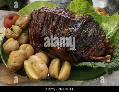 Oie farcie et rôtie recouverte de bacon servi avec des pommes de terre cuites au four. Banque D'Images