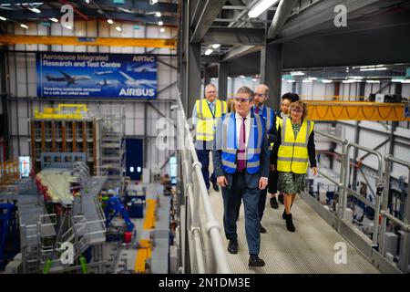 Sir Keir Starmer (à gauche), le leader du travail, et Jonathan Reynolds, le secrétaire d'entreprise fantôme du Parti travailliste (dans le centre bleu des vestes de haute visibilité), marchent avec Sue Partridge (à droite), la tête du site de Filton, sur un portique pour voir les essais des ailes de l'avion, lors d'une visite à Airbus, Le Centre intégré de recherche et d'essais aérospatiaux (Airtec) de Filton, Bristol. Date de la photo: Lundi 6 février 2023. Banque D'Images