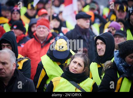 Berlin, Allemagne. 06th févr. 2023. Un démonstrateur porte un chapeau avec le logo de la poste tout en frappant avec d'autres employés de Deutsche Post devant le siège fédéral de Ver.di sur Schilingbrücke. Les manifestants exigent 15 pour cent de plus de salaire pour les travailleurs postaux. Credit: Annette Riedl/dpa/Alay Live News Banque D'Images