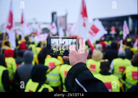 Berlin, Allemagne. 06th févr. 2023. Le démonstrateur filme la grève d'avertissement devant le siège fédéral de Ver.di sur le Schilingbrücke. Les manifestants exigent 15 pour cent de plus de salaire pour les travailleurs postaux. Credit: Annette Riedl/dpa/Alay Live News Banque D'Images