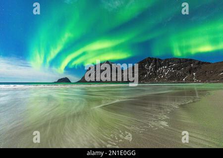 Vagues s'écrasant sur la plage surgelée de Haukland sous les aurores boréales (Aurora Borealis), Leknes, comté de Nordland, îles Lofoten, Norvège, Scandinavie Banque D'Images