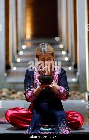 Bol tibétain, femme bouddhiste pratiquant un bol de chant pour la thérapie sonore dans l'atmosphère pour la guérison, la méditation, le yoga et la relaxation, Quang Ninh, Vietn Banque D'Images