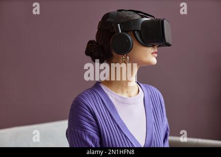 Portrait d'une jeune femme portant des lunettes VR avec casque Banque D'Images