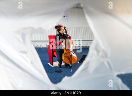 Su-a Lee, le principal violoncelliste du Scottish Chamber Orchestra, joue auprès d'un public de travailleurs de la construction lors d'une conférence de presse marquant le premier jour de travail pour nettoyer le site près de St Andrew Square, à Édimbourg, en amont de la construction du Dunard Centre, la nouvelle salle de concert de classe mondiale de la ville. Date de la photo: Lundi 6 février 2023. Banque D'Images