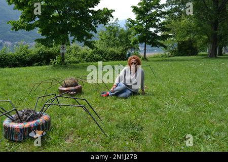 Lecco,Italie-14 mai 2016: L'artiste locale Franca Carzaniga pose près de sculptures créées par elle et appelées “3 ottavi” dans le cadre d'un projet local. Banque D'Images