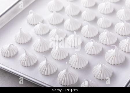 Meringue embrasse sur une plaque de cuisson prête à être cuite, idée de biscuits faits maison Banque D'Images