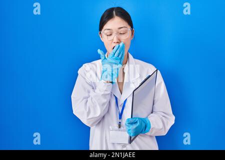 La jeune femme chinoise travaillant au laboratoire scientifique s'ennuyait à bâiller fatiguée en couvrant la bouche avec la main. agité et somnolence. Banque D'Images