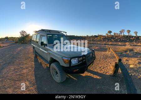 Véhicule hors route Toyota Land Cruiser 4WD rétroéclairé stationné à la forêt de quiver Tree, près de Keetmanshoop, Namibie. Banque D'Images