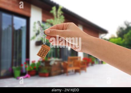 Agent immobilier tenant la clé contre la maison moderne, fermé Banque D'Images