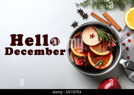 Carte de vœux Hello December. Casserole avec un bon vin chaud sur la table, poser à plat Banque D'Images