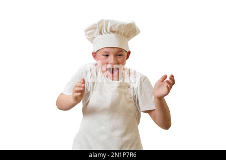 Un enfant en vêtements de chef blanc cuisine la nourriture dans une cuisine maison, isolée sur un fond blanc Banque D'Images