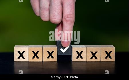 Main sélectionne un cube noir. Symbole de prise de décision. Banque D'Images