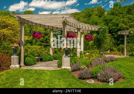 Vue magnifique sur un jardin d'été luxuriant avec paniers suspendus. Banque D'Images