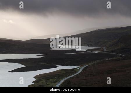 Voiture sur la A855, qui serpente autour du Loch Leathan et du Loch Fada, île de Skye, Écosse Banque D'Images