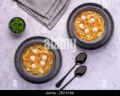 Photographie alimentaire de soupe avec boulettes de viande et nouilles, légumes, carottes, ciboulettes, pommes de terre Banque D'Images