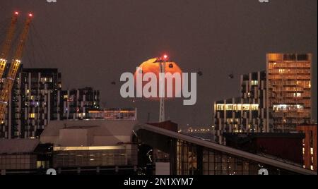 Londres, Royaume-Uni. 6th février 2023. Météo au Royaume-Uni: 99,1% pleine lune fait des silhouettes de passage de téléphériques, également connu sous le nom de téléphérique d'IFS Cloud dans l'est de Londres. Credit: Guy Corbishley/Alamy Live News Banque D'Images