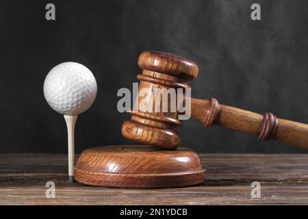 Droit dans le golf. Jugez le gavel et le ballon de golf sur fond de bois. Concept de droit sportif et de crimes sportifs Banque D'Images