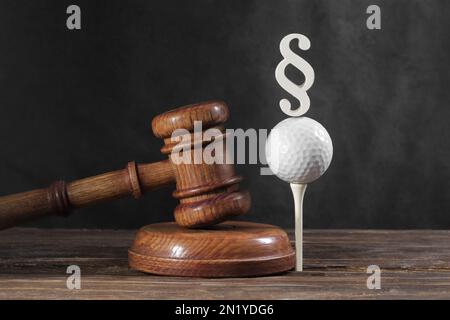 Droit dans le golf. Jugez le gavel et le ballon de golf sur fond de bois. Concept de droit sportif et de crimes sportifs Banque D'Images