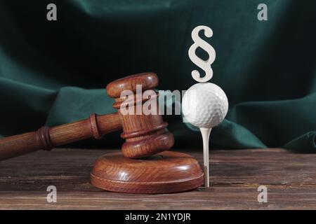 Droit dans le golf. Jugez le gavel et le ballon de golf sur fond de bois. Concept de droit sportif et de crimes sportifs Banque D'Images