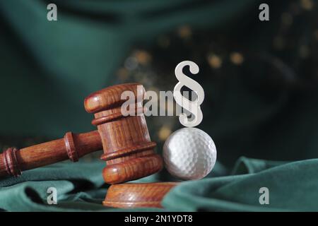 Droit dans le golf. Jugez le gavel et le ballon de golf sur fond de bois. Concept de droit sportif et de crimes sportifs Banque D'Images