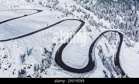 Route sinueuse dans un paysage d'hiver d'un col de montagne. Route sinueuse recouverte de neige. Vacances, voyage, conduite, itinéraire, voyage et tourisme concep Banque D'Images