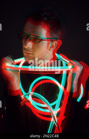 Glitch Double Exposure Portrait futuriste en beau jeune hipster homme avec des lunettes tendance sur enveloppé de ruban lumineux au néon Banque D'Images