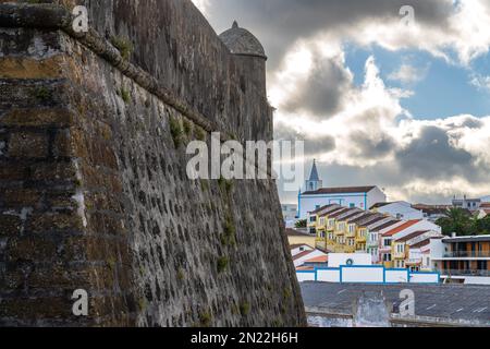Les murs massifs de pierre du 16th siècle côte forte de São Sebastião et vue sur la zone portuaire à Angra do Heroismo, l'île de Terceira, Açores, Portugal. Banque D'Images